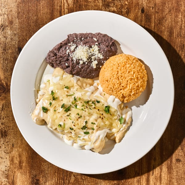 Latin-American dish with enchiladas, refried beans, and rice on a white plate.