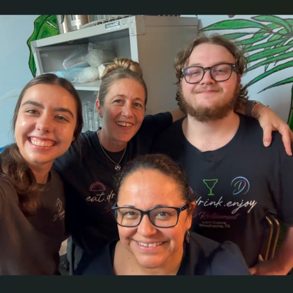 Four smiling D Restaurant staff members, two men and two women, pose for a group photo.
